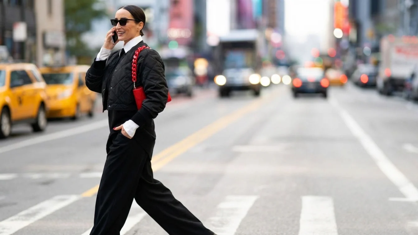 Well-dressed businesswoman walking on the street of Manhattan, New York and talking on the phone while heading to work during one autumn day.