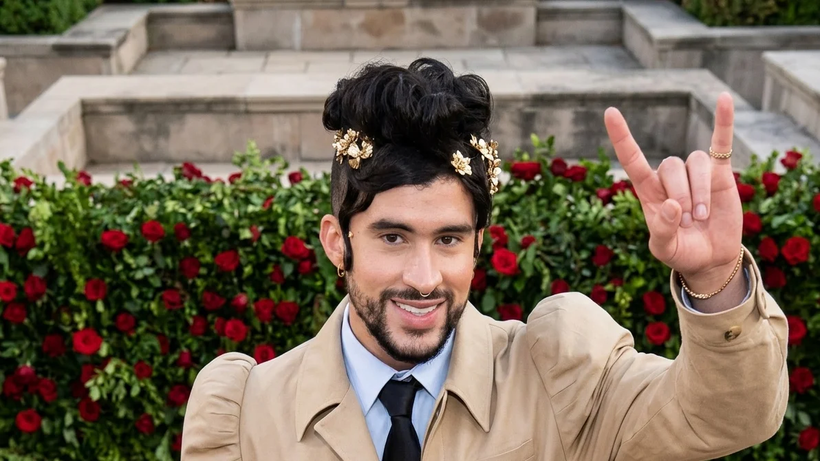 Image may contain Bad Bunny Black Hair Hair Person Adult Face Head Clothing Coat Accessories Formal Wear and Tie