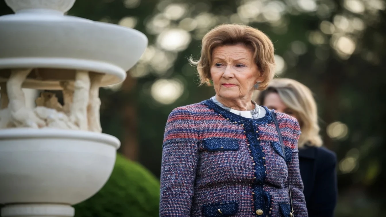Queen Sonja next to a stone fountain