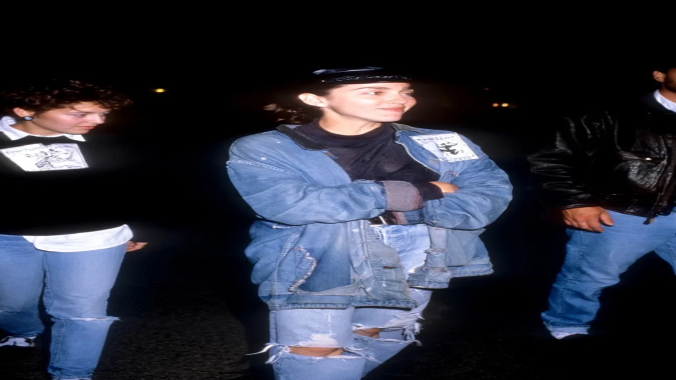 Image may contain Madonna Clothing Pants Jeans Coat Jacket Adult Person Face Head Photography Portrait and Vest