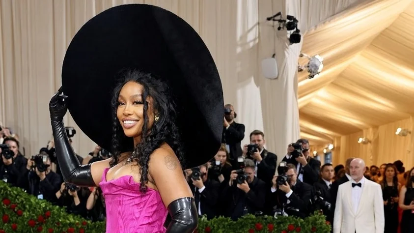 Image may contain SZA Fashion Clothing Dress Adult Person Costume Formal Wear Gown Purple Face and Head