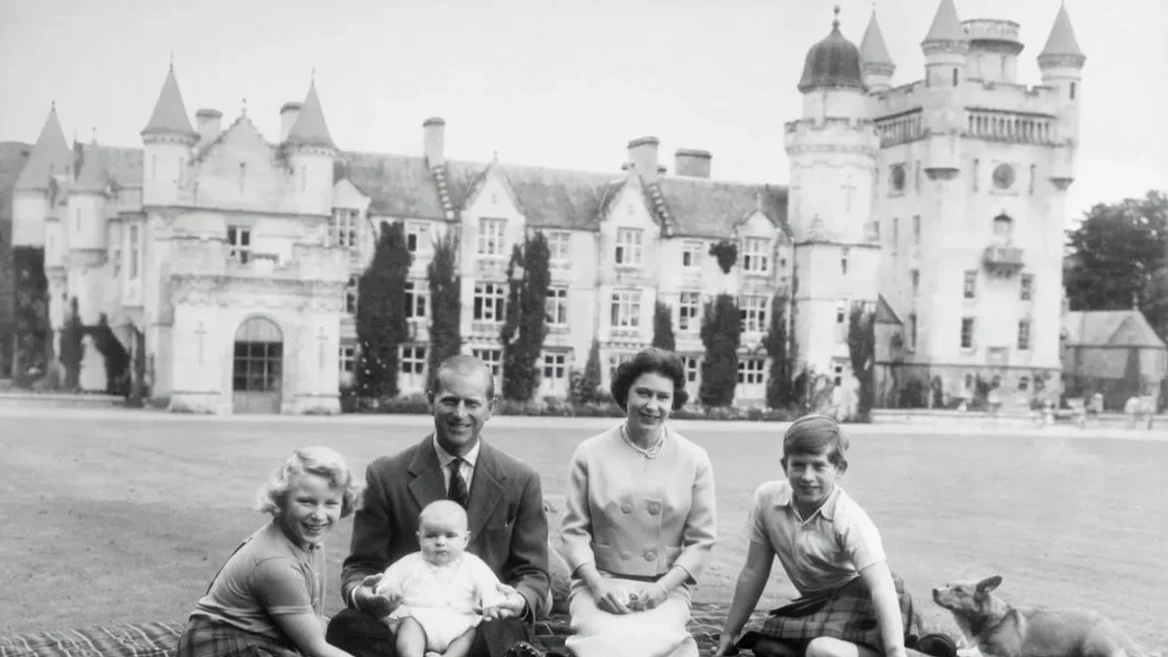 Queen Elizabeth II and Prince Philip, Duke of Edinburgh with their children, Prince Andrew (centre), Princess Anne (left) and Charles, Prince of Wales sitting on a picnic rug outside Balmoral Castle