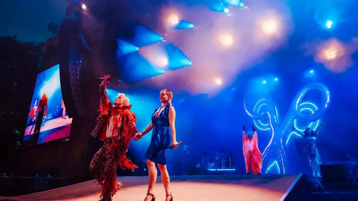 Kelly wearing heels and mini dress on stage