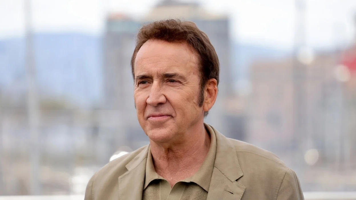 Nicolas Cage in 2024 wearing a beige polo shirt and suit jacket.